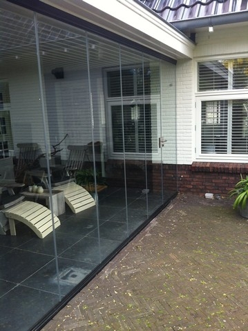 Black aluminum bifold glass doors fully opened connecting indoor living space to outdoor patio area