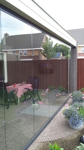 Black aluminum bifold glass doors fully opened connecting indoor living space to outdoor patio area