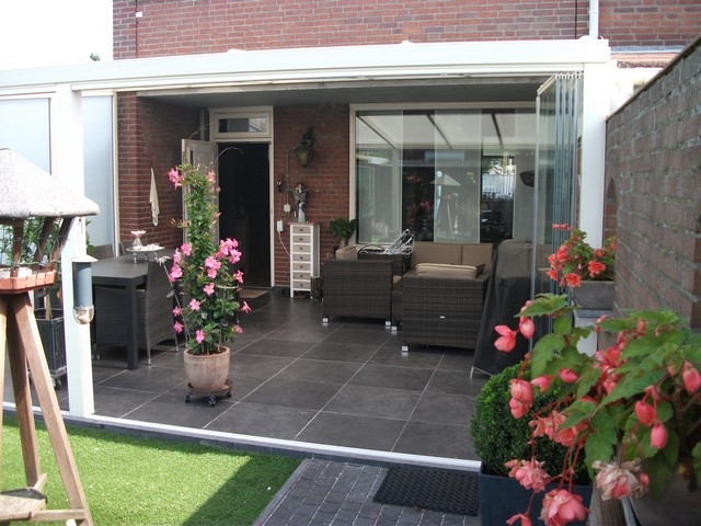 Black aluminum bifold glass doors fully opened connecting indoor living space to outdoor patio area
