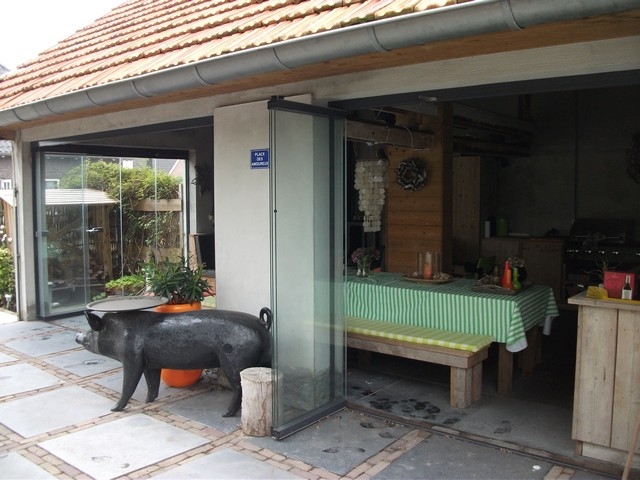 Black aluminum bifold glass doors fully opened connecting indoor living space to outdoor patio area