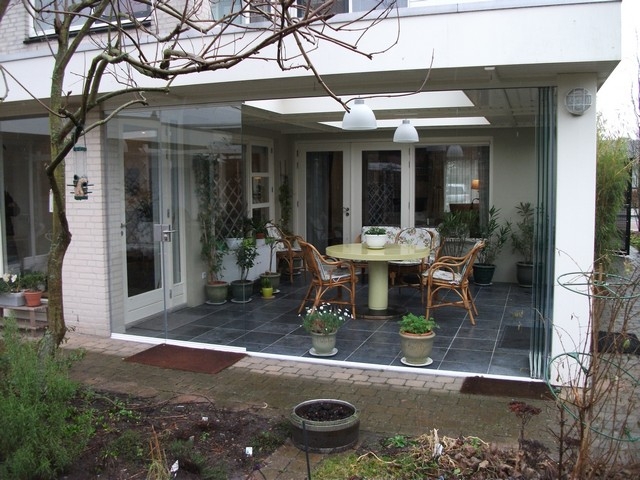 Black aluminum bifold glass doors fully opened connecting indoor living space to outdoor patio area