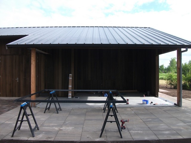Black aluminum bifold glass doors fully opened connecting indoor living space to outdoor patio area