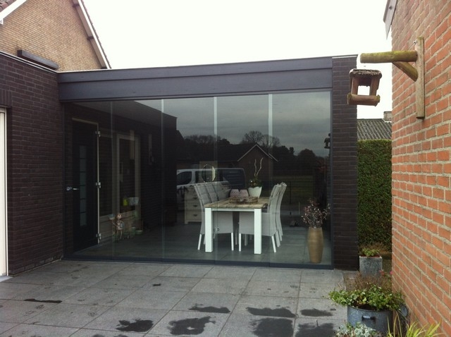 Black aluminum bifold glass doors fully opened connecting indoor living space to outdoor patio area