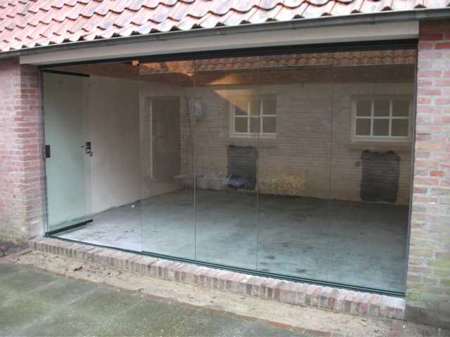 Black aluminum bifold glass doors fully opened connecting indoor living space to outdoor patio area