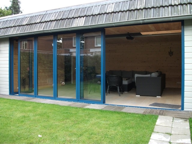 Black aluminum bifold glass doors fully opened connecting indoor living space to outdoor patio area