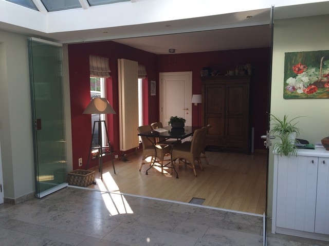 Black aluminum bifold glass doors fully opened connecting indoor living space to outdoor patio area