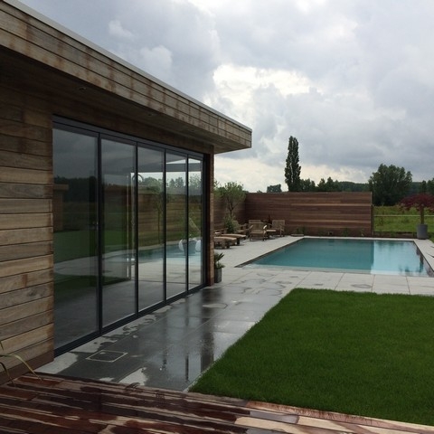 Black aluminum bifold glass doors fully opened connecting indoor living space to outdoor patio area