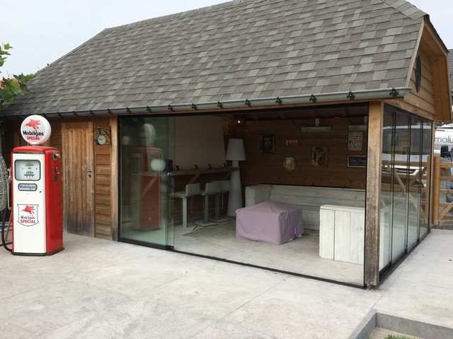Black aluminum bifold glass doors fully opened connecting indoor living space to outdoor patio area