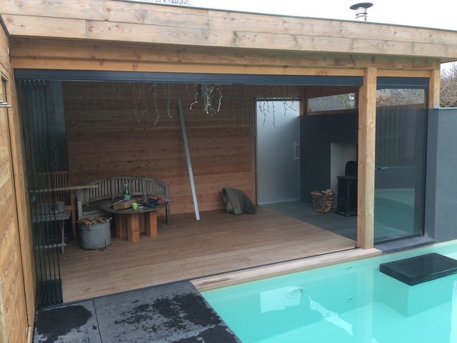 Black aluminum bifold glass doors fully opened connecting indoor living space to outdoor patio area