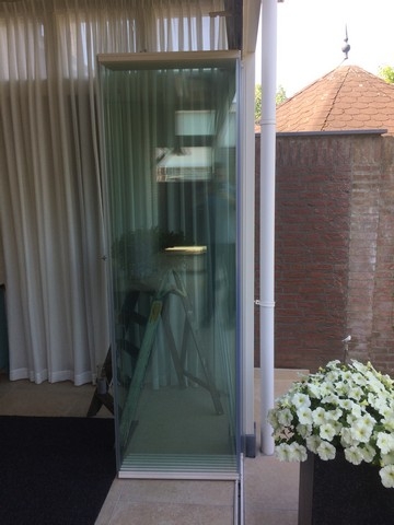 Black aluminum bifold glass doors fully opened connecting indoor living space to outdoor patio area