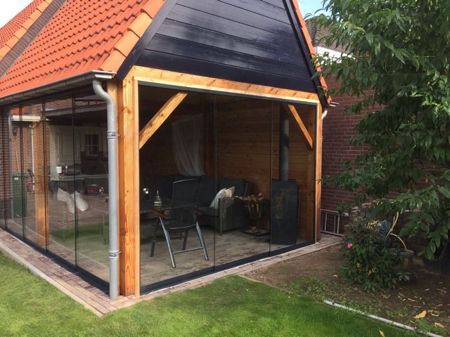Black aluminum bifold glass doors fully opened connecting indoor living space to outdoor patio area