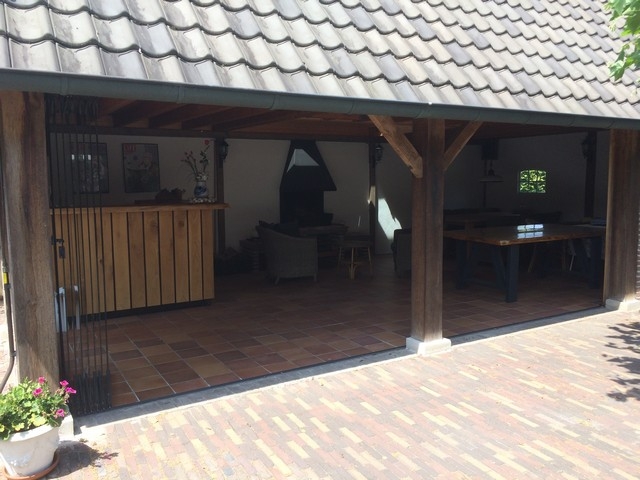 Black aluminum bifold glass doors fully opened connecting indoor living space to outdoor patio area