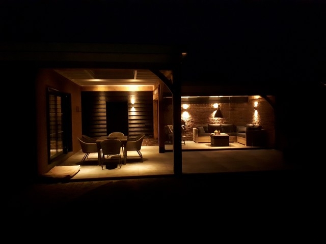 Black aluminum bifold glass doors fully opened connecting indoor living space to outdoor patio area