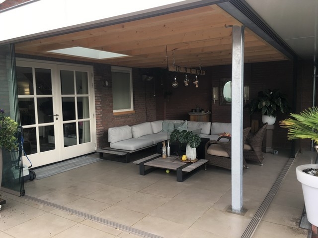 Black aluminum bifold glass doors fully opened connecting indoor living space to outdoor patio area