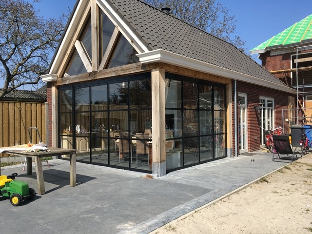 Black aluminum bifold glass doors fully opened connecting indoor living space to outdoor patio area