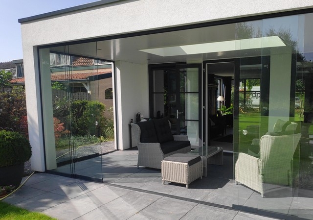 Black aluminum bifold glass doors fully opened connecting indoor living space to outdoor patio area