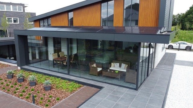 Black aluminum bifold glass doors fully opened connecting indoor living space to outdoor patio area