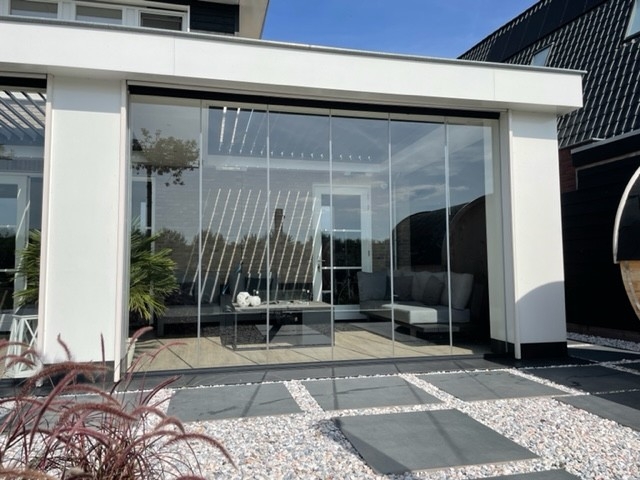 Black aluminum bifold glass doors fully opened connecting indoor living space to outdoor patio area