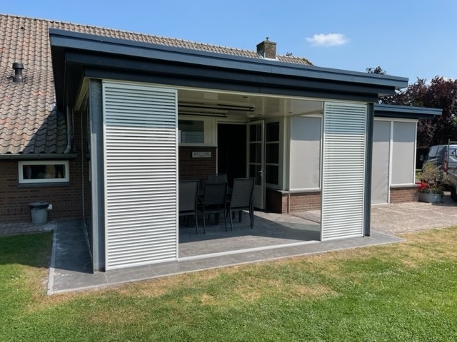 Black aluminum bifold glass doors fully opened connecting indoor living space to outdoor patio area