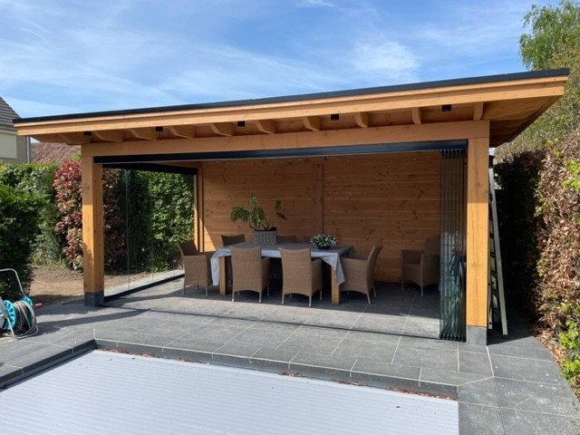 Black aluminum bifold glass doors fully opened connecting indoor living space to outdoor patio area