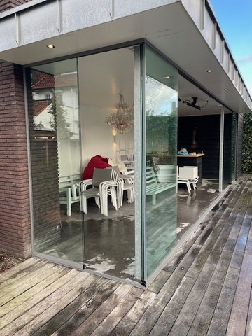 Black aluminum bifold glass doors fully opened connecting indoor living space to outdoor patio area