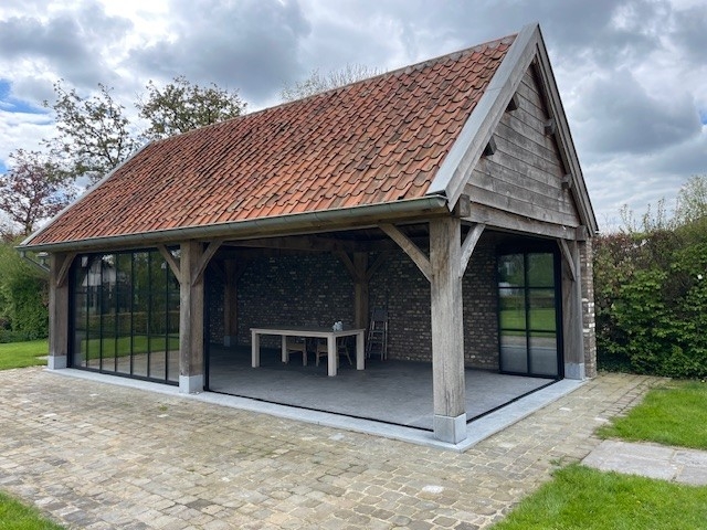 Black aluminum bifold glass doors fully opened connecting indoor living space to outdoor patio area