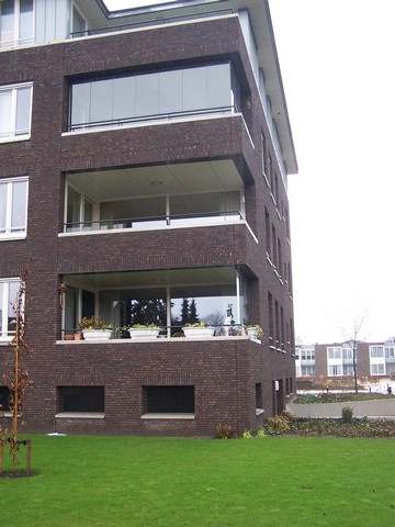 Black aluminum bifold glass doors fully opened connecting indoor living space to outdoor patio area