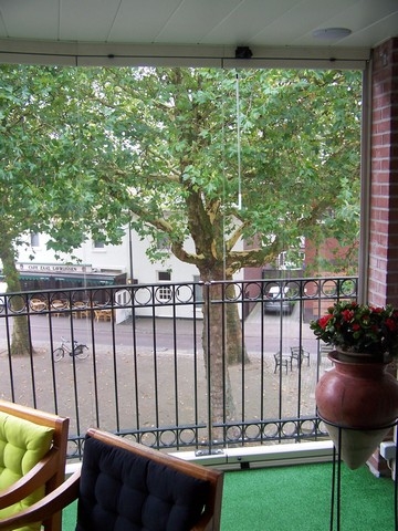 Black aluminum bifold glass doors fully opened connecting indoor living space to outdoor patio area