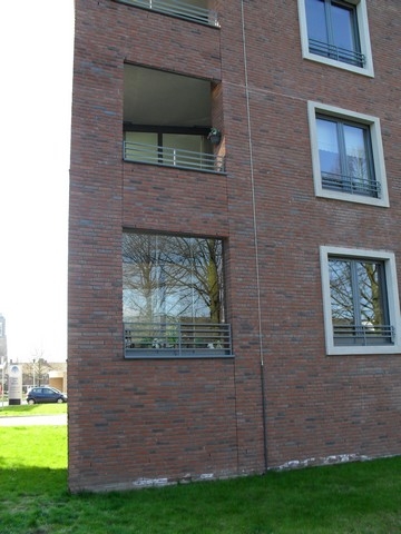 Black aluminum bifold glass doors fully opened connecting indoor living space to outdoor patio area