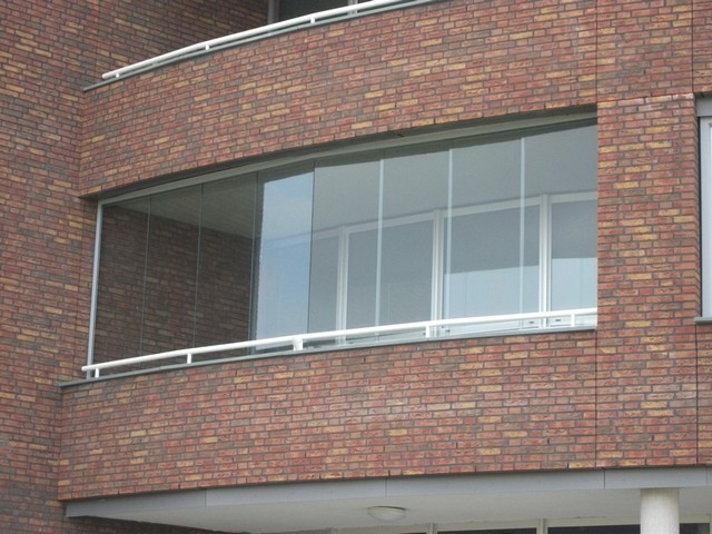 Black aluminum bifold glass doors fully opened connecting indoor living space to outdoor patio area