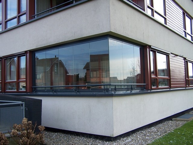 Black aluminum bifold glass doors fully opened connecting indoor living space to outdoor patio area