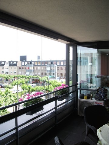 Black aluminum bifold glass doors fully opened connecting indoor living space to outdoor patio area