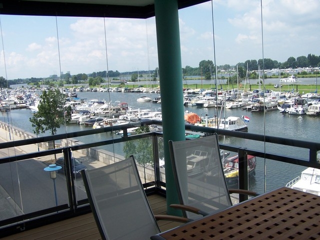 Black aluminum bifold glass doors fully opened connecting indoor living space to outdoor patio area
