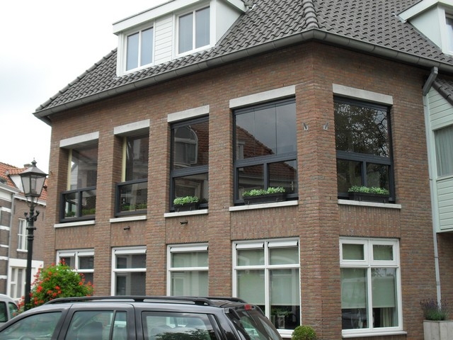 Black aluminum bifold glass doors fully opened connecting indoor living space to outdoor patio area