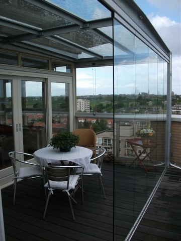 Black aluminum bifold glass doors fully opened connecting indoor living space to outdoor patio area