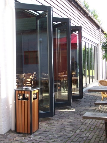 Black aluminum bifold glass doors fully opened connecting indoor living space to outdoor patio area