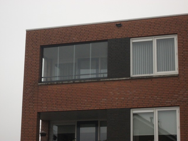 Black aluminum bifold glass doors fully opened connecting indoor living space to outdoor patio area