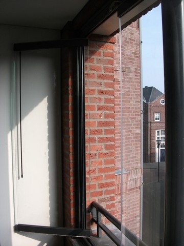 Black aluminum bifold glass doors fully opened connecting indoor living space to outdoor patio area