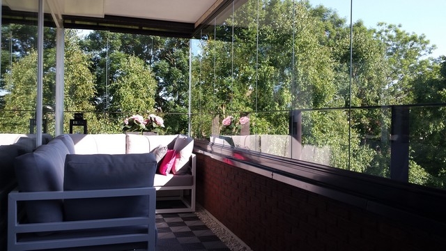 Black aluminum bifold glass doors fully opened connecting indoor living space to outdoor patio area