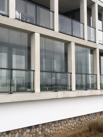 Black aluminum bifold glass doors fully opened connecting indoor living space to outdoor patio area