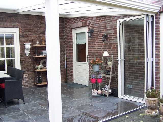 Black aluminum bifold glass doors fully opened connecting indoor living space to outdoor patio area