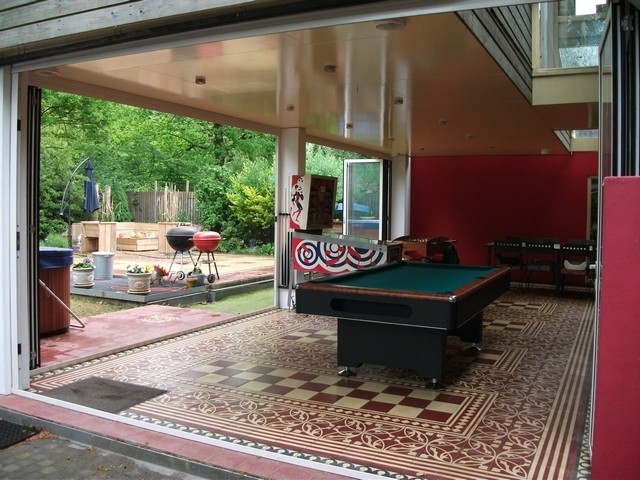 Black aluminum bifold glass doors fully opened connecting indoor living space to outdoor patio area