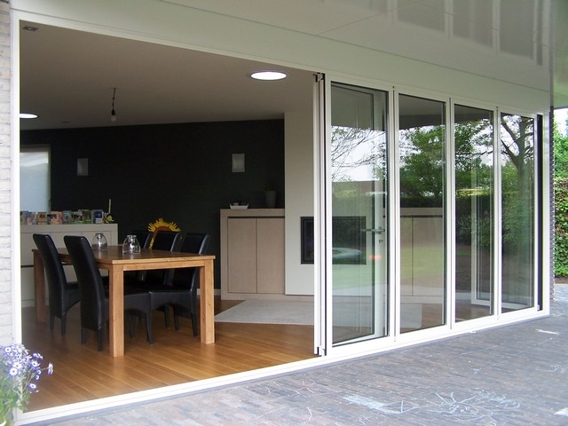 Black aluminum bifold glass doors fully opened connecting indoor living space to outdoor patio area