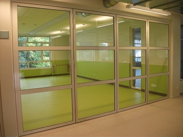 Black aluminum bifold glass doors fully opened connecting indoor living space to outdoor patio area