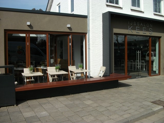 Black aluminum bifold glass doors fully opened connecting indoor living space to outdoor patio area