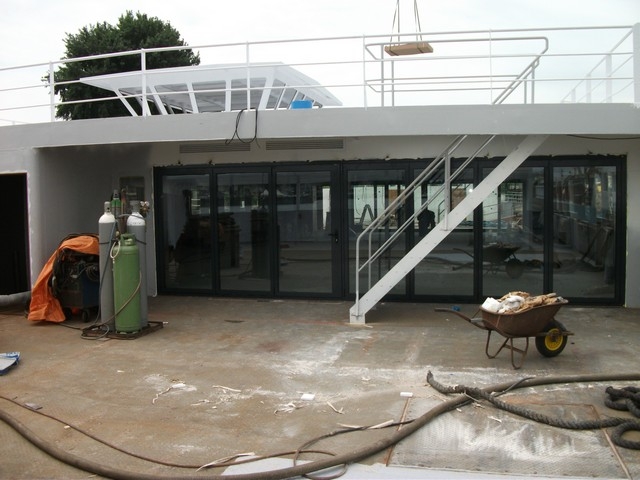 Black aluminum bifold glass doors fully opened connecting indoor living space to outdoor patio area