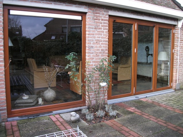 Black aluminum bifold glass doors fully opened connecting indoor living space to outdoor patio area