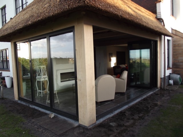 Black aluminum bifold glass doors fully opened connecting indoor living space to outdoor patio area