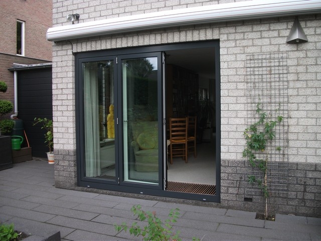 Black aluminum bifold glass doors fully opened connecting indoor living space to outdoor patio area