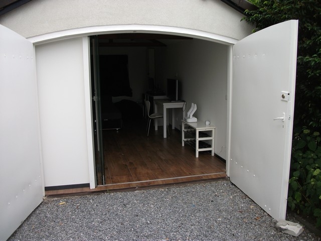 Black aluminum bifold glass doors fully opened connecting indoor living space to outdoor patio area
